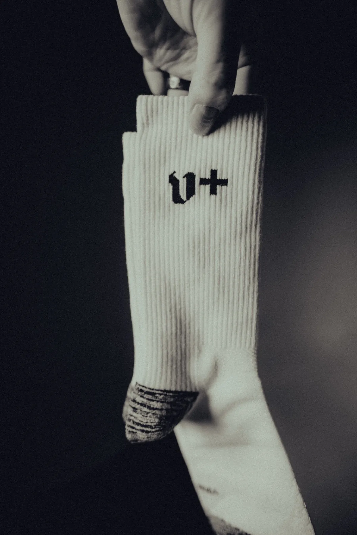 Single sock suspended against black, v+ cuff
